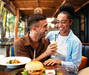 Couple smiling while enjoying meal at restaurant