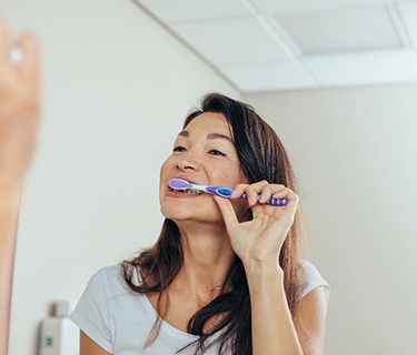 Woman brushing her teeth in bathroom