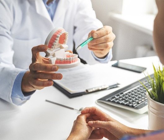 Fort Worth dentist pointing to model of teeth