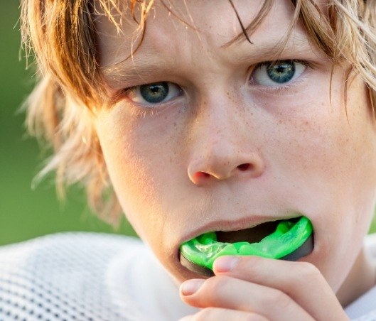 Young boy placing an athletic mouthguard in Fort Worth into his mouth