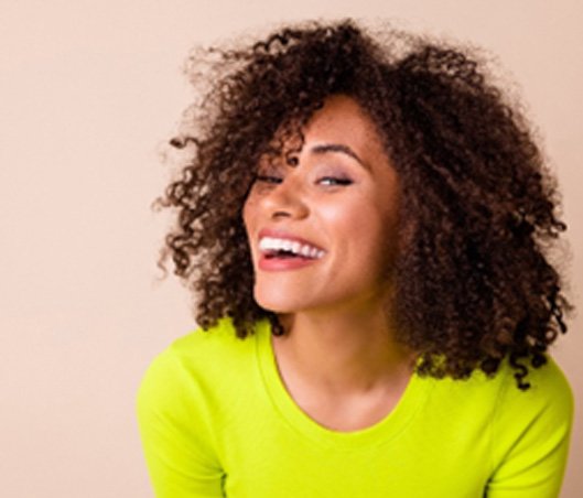 Woman in neon green shirt smiling at camera