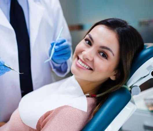 Young woman smiling while visiting her dentist for preventive dentistry in Fort Worth