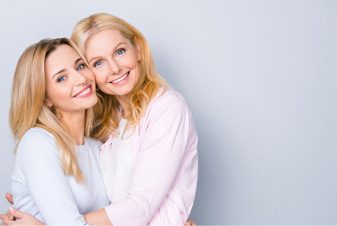 Smiling mother and daughter hugging