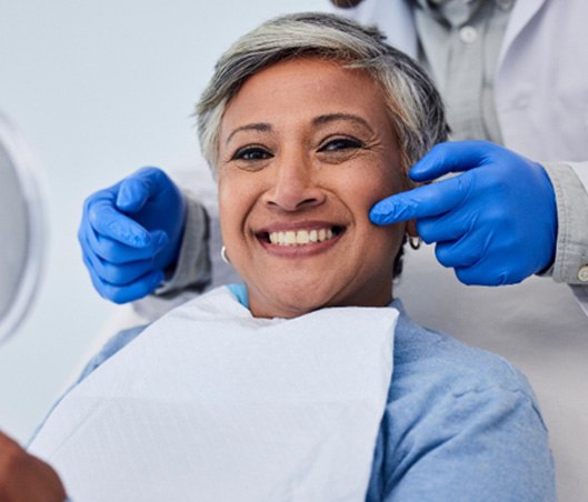 a smiling woman sitting in a dental chair