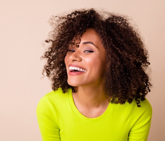 Woman in chartreuse shirt smiling.