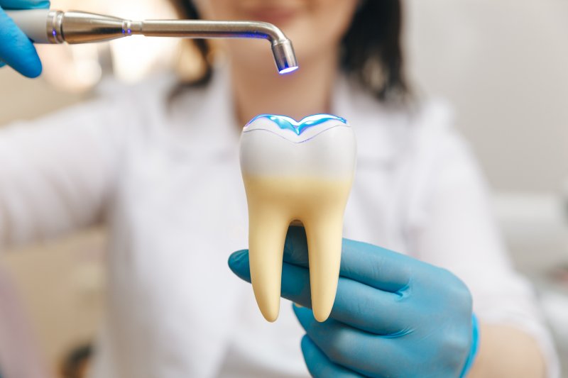 A dentist pretending to give a filling to a fake tooth




