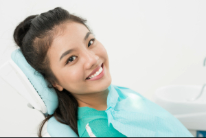 Woman sitting back in dental chair showing off her smile