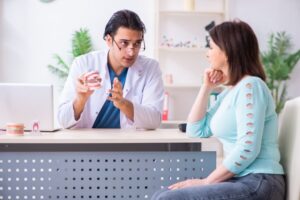 a dentist explaining full-mouth reconstruction to a female patient